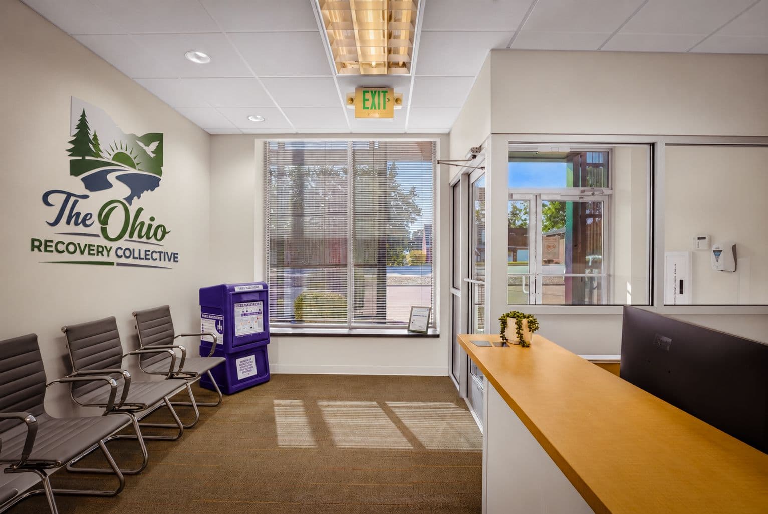 The reception area, with waiting chairs and the logo on the wall