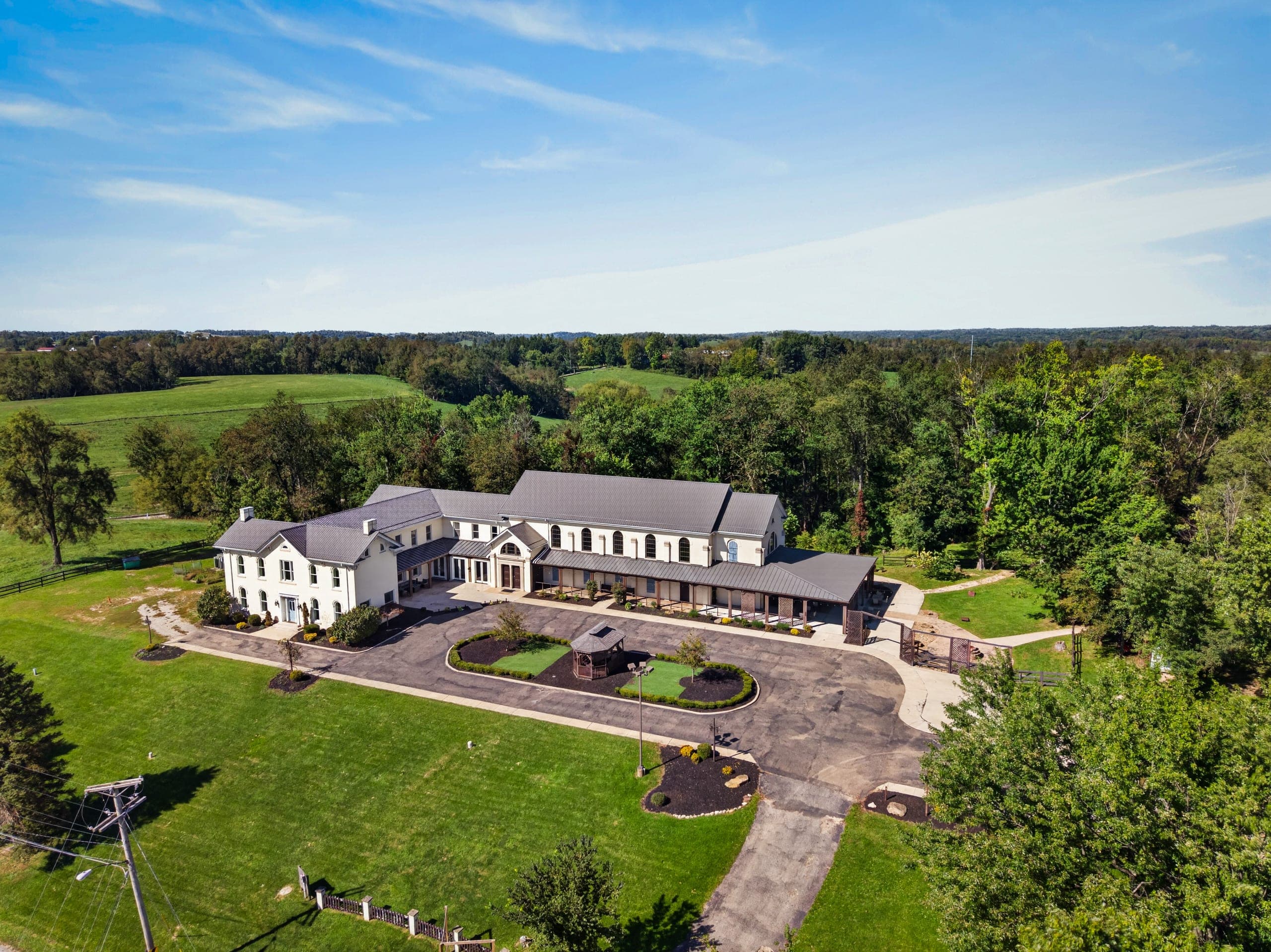 The house from above, surrounded by fields and woodland