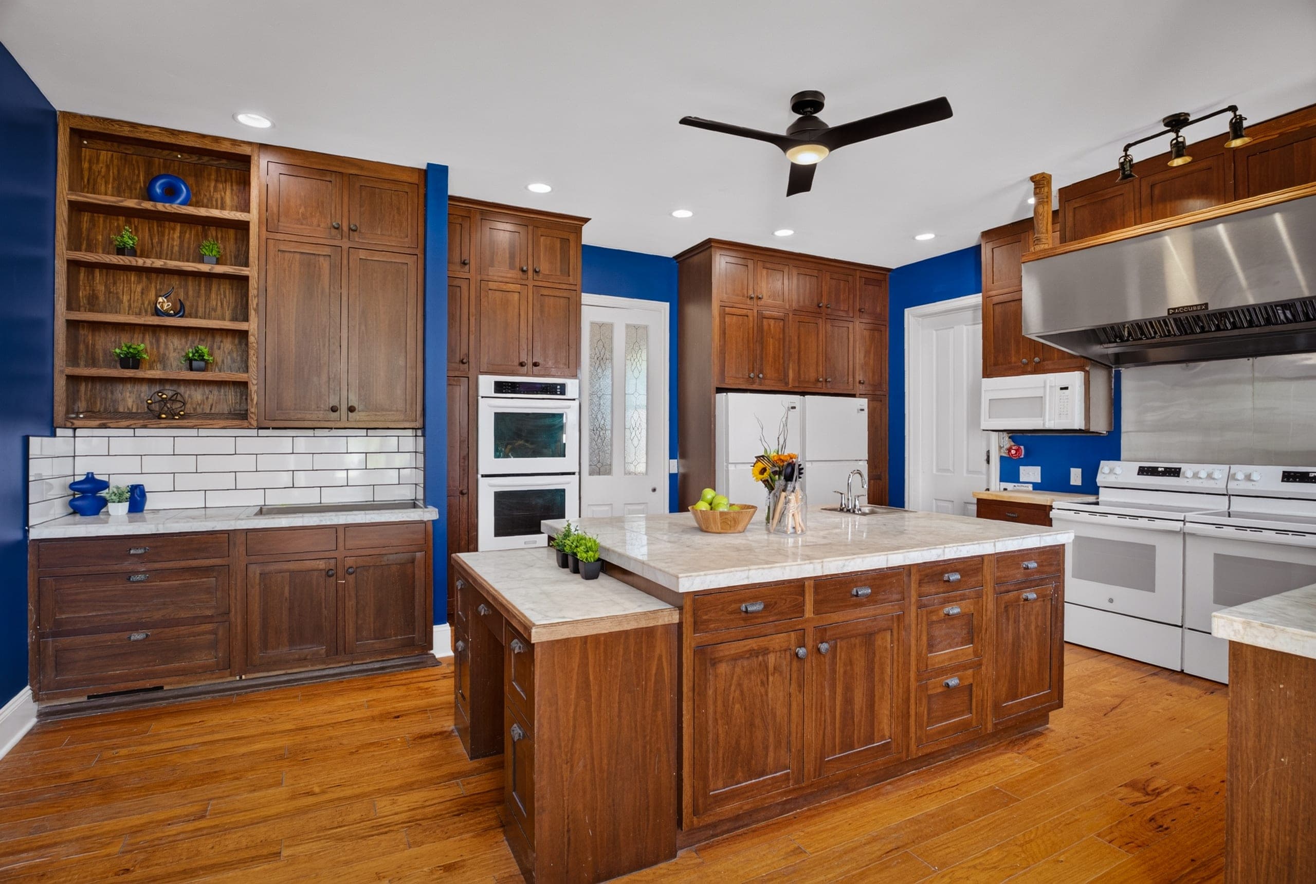A kitchen with wood cabinets and a large island