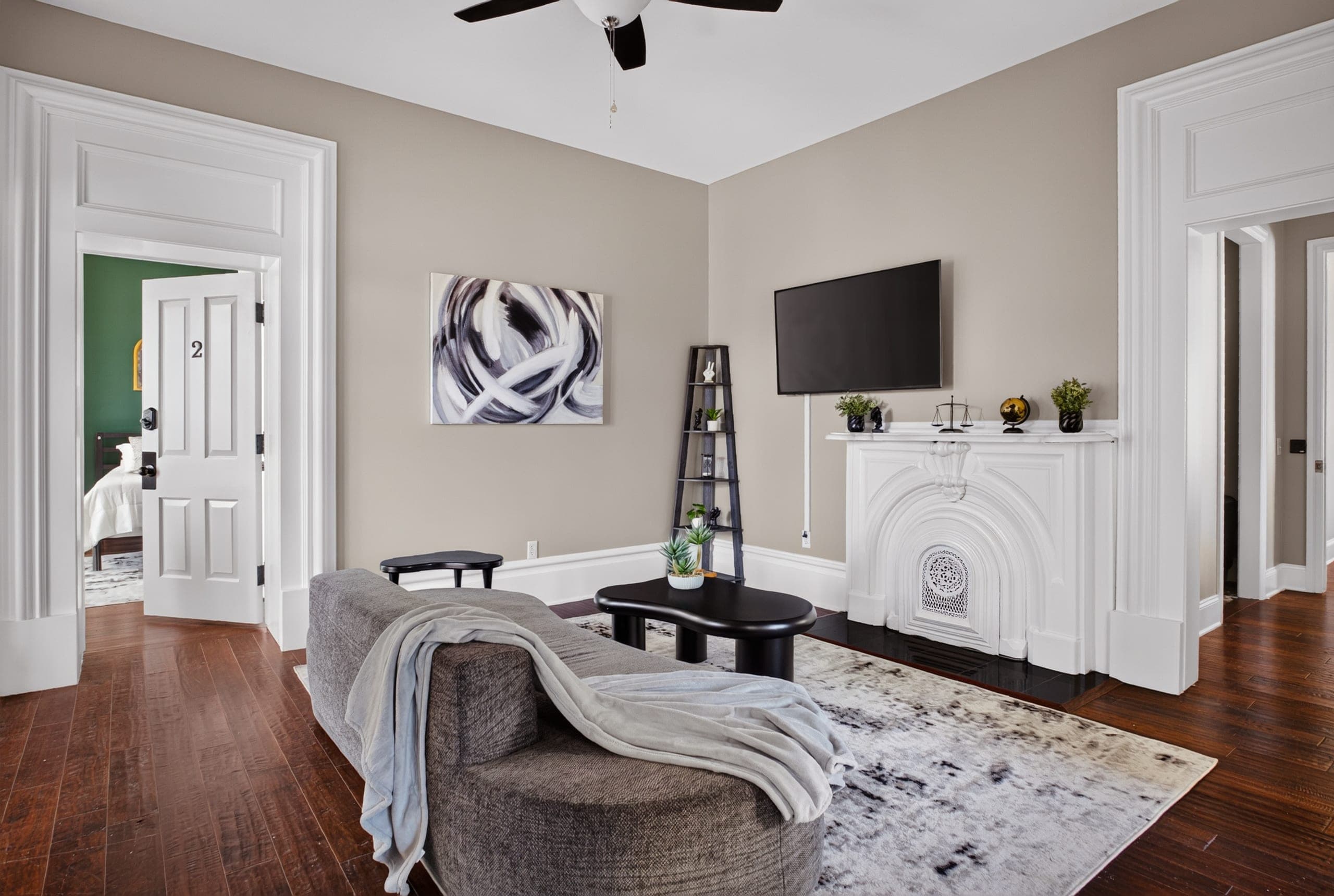 A living room with hardwood floors and a white mantel
