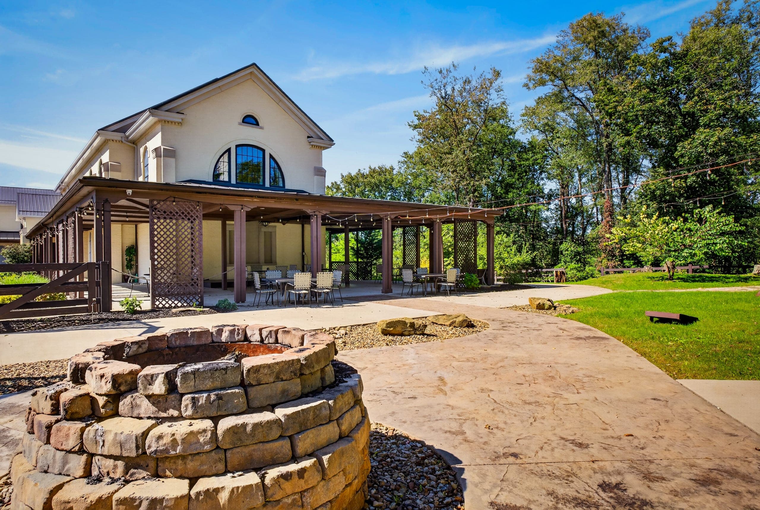 A covered patio with a stone fire pit