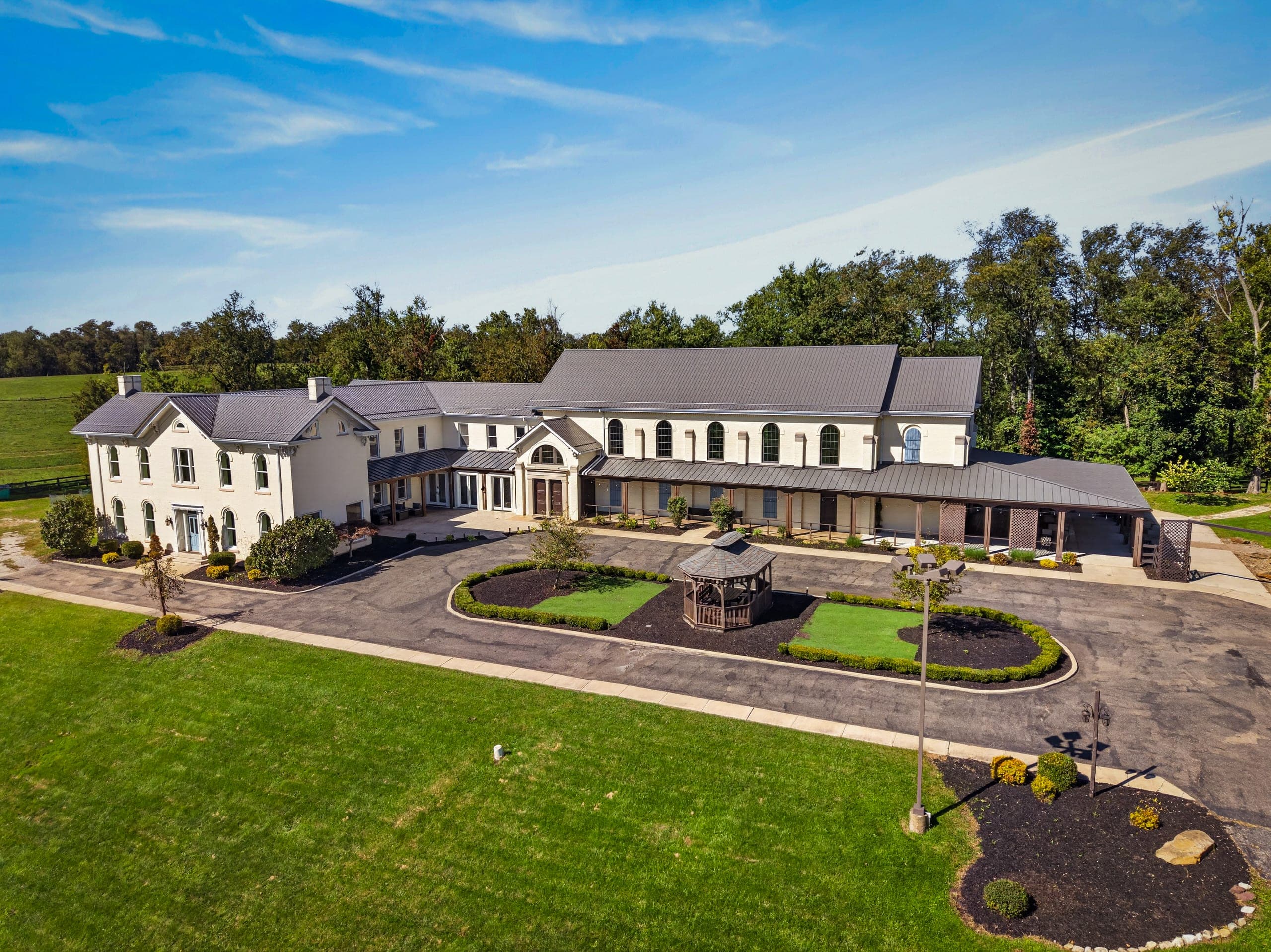 The men’s residence, a large white building behind a circular drive with a gazebo